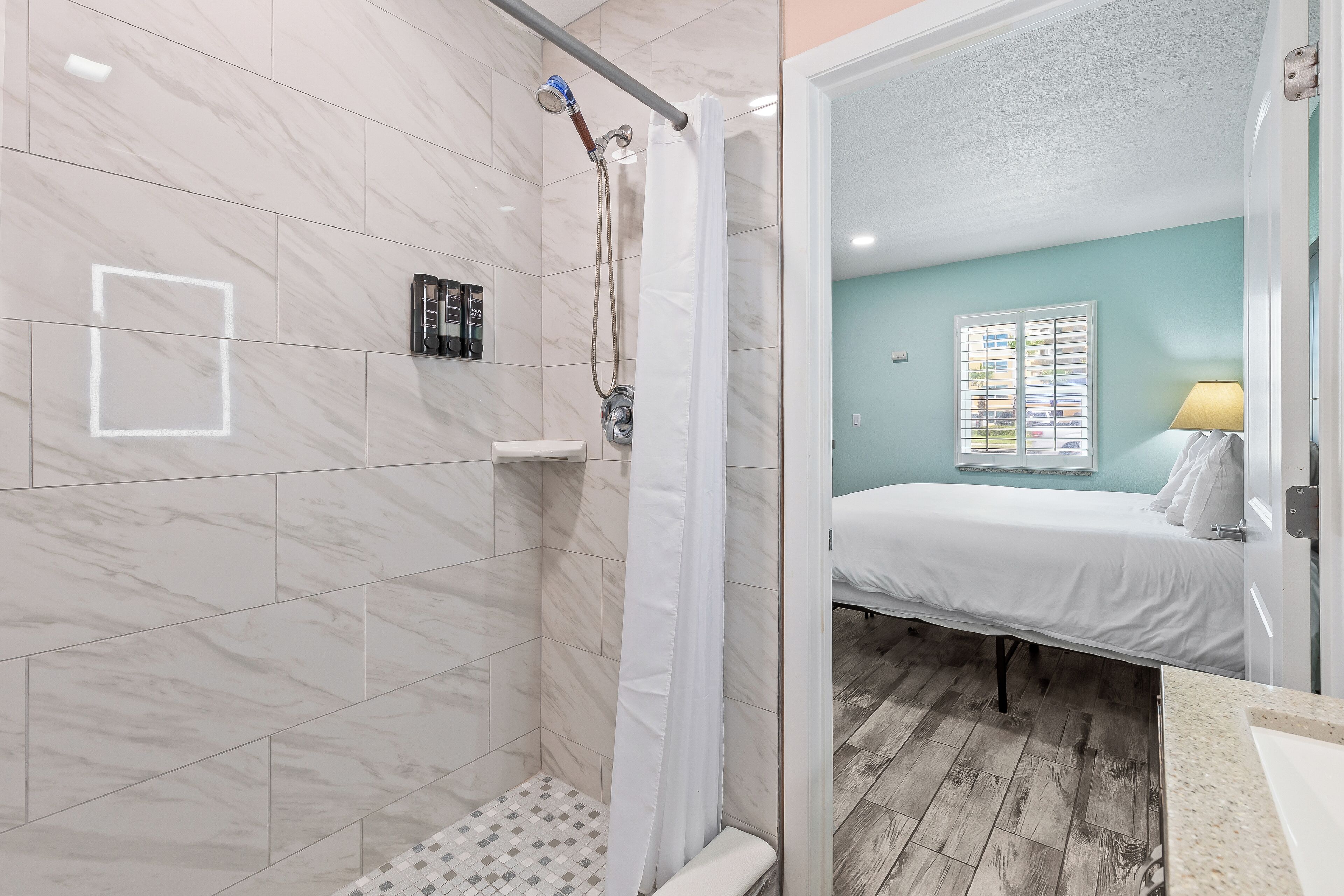 A bathroom with a shower, a toilet, and a sink.