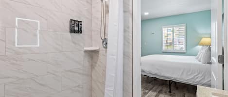 A bathroom with a shower, a toilet, and a sink.