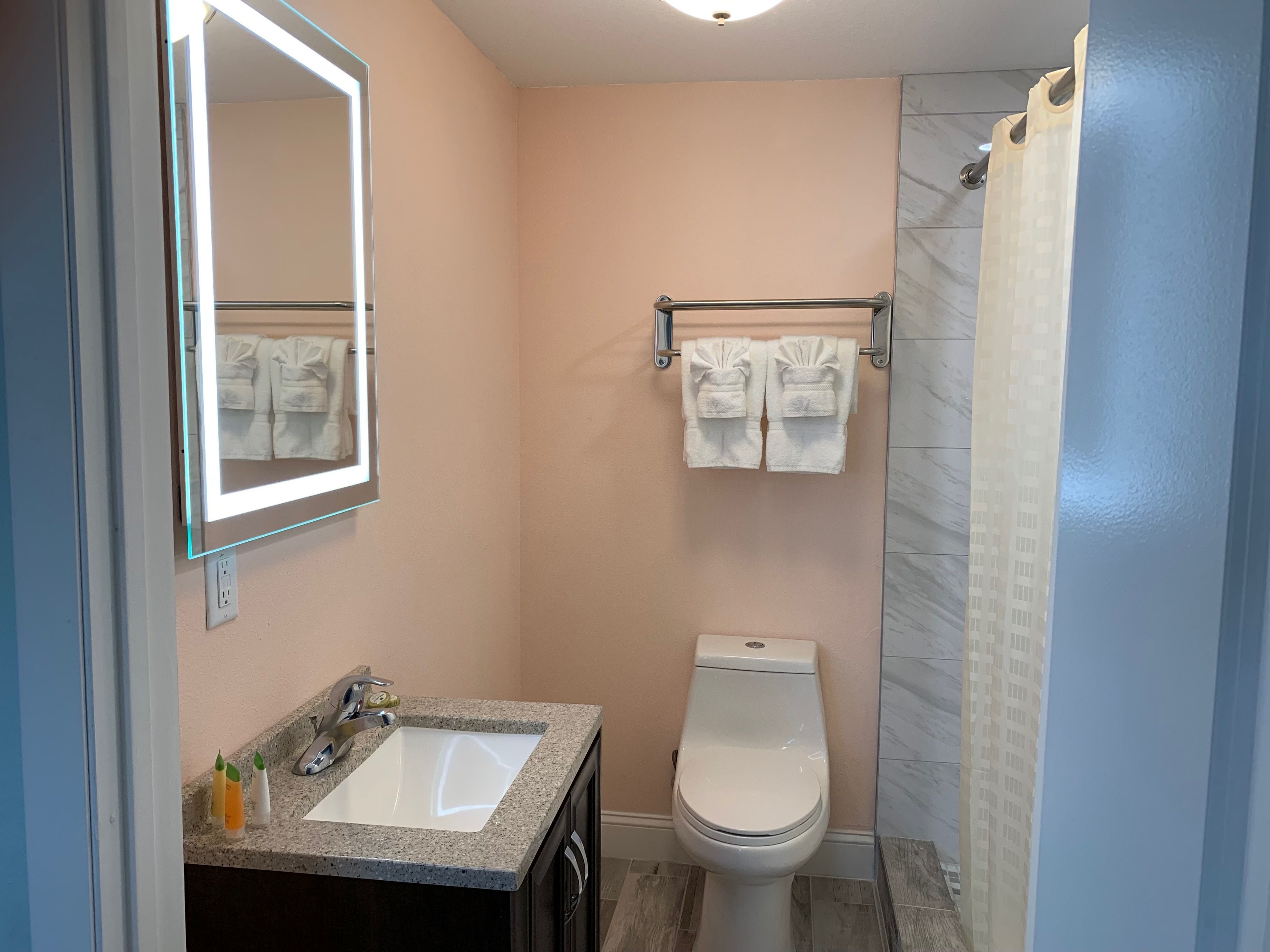 Un baño pequeño con lavamanos, inodoro y toallero.
