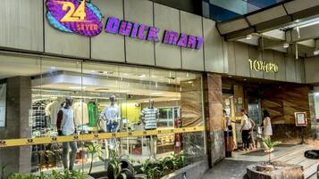 Een 24 SEVEN QUICK MART winkel met mannequins waarop kleding wordt gepresenteerd.