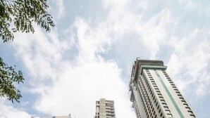 Una calle urbana con edificios altos, una senda peatonal y comercios.