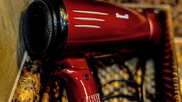 A red hair dryer in a wicker basket.