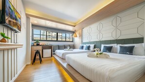 A hotel room with two beds, a desk, a TV, and a window with a city view. - Tori Prestige Bangkok Hotel (Bangkok)