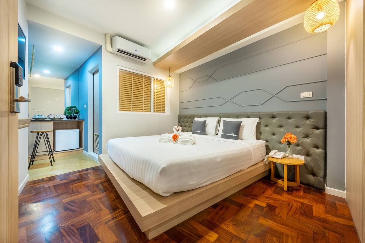 Une chambre d’hôtel moderne avec un grand lit, un petit bureau et une vue sur la ville.