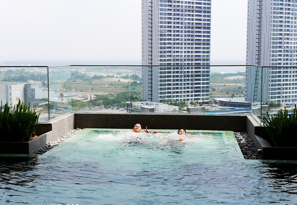 Relax by the serene indoor pool, surrounded by a stunning city view.
