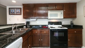 A kitchen with wooden cabinets, a microwave, a stove, and a dishwasher. - 1 Bedroom with Private Waterfront Balcony (Willis)