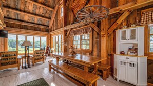 A rustic wooden interior with a large wooden table, benches, and a white cabinet. - Mountain Lodge Retreat (Newry)