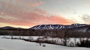Un paysage enneigé avec une chaîne de montagnes en arrière-plan et un ciel dégagé.