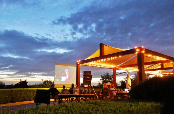 Enjoy an outdoor movie night under the stars in our serene grassy field with a large screen and cozy seating area.