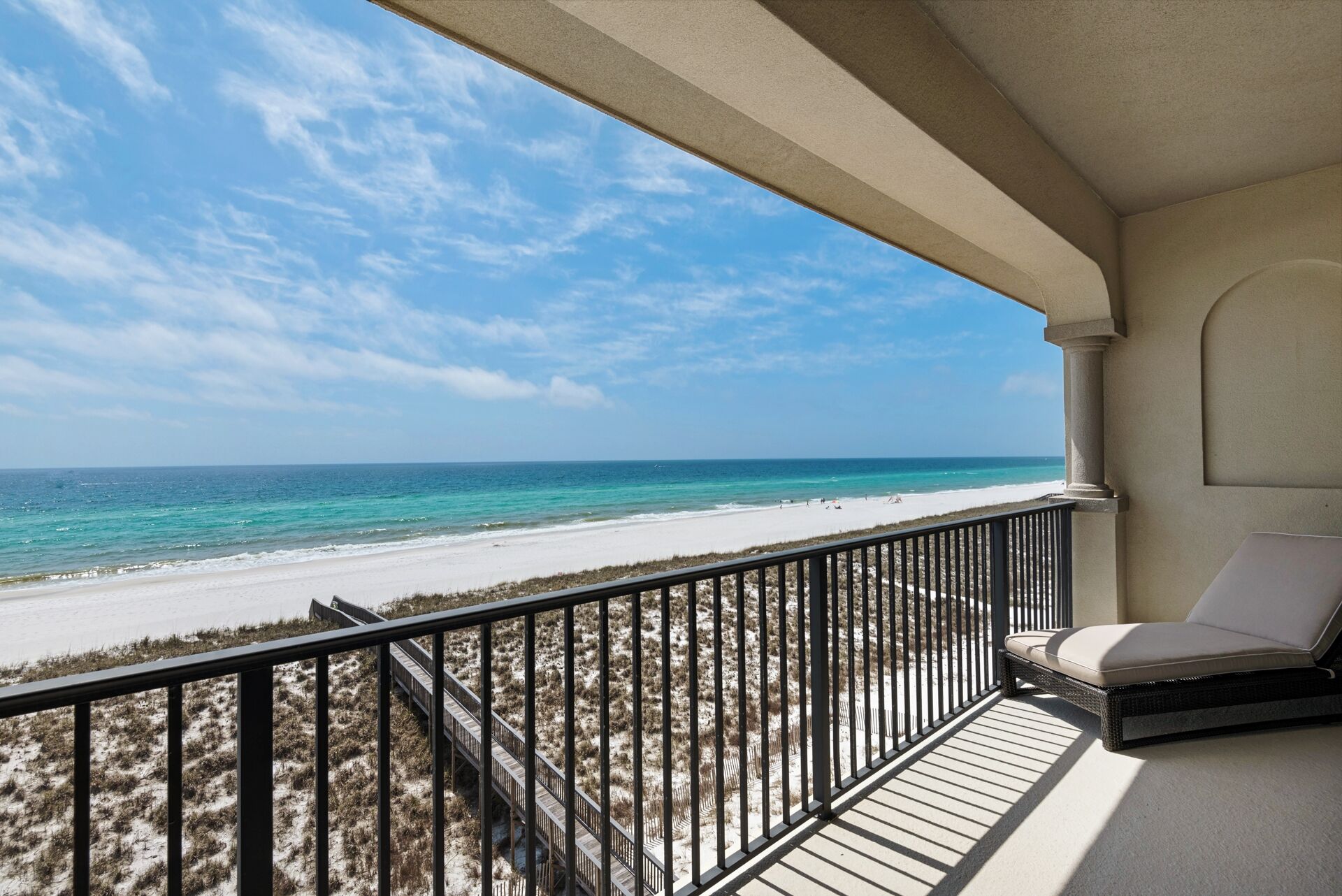 A balcony with a view of a beach and ocean.
