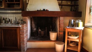 A kitchen with a brick fireplace, wooden shelves, and a tiled backsplash. - Rustic renovated, with every modern comfort, private pool and garden (Domazzano)