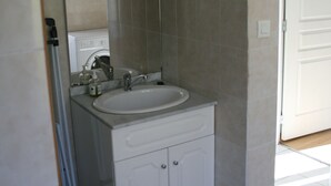 A bathroom with a white sink, mirror, and tiled walls. - accommodation for up to 12 people (Ferrières-Saint-Mary)