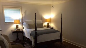 A four-poster bed with two bedside tables, a chair, and a ceiling fan. - Charming Summer + Fall Football Rental - Near Square & Ole Miss Camp (Oxford)