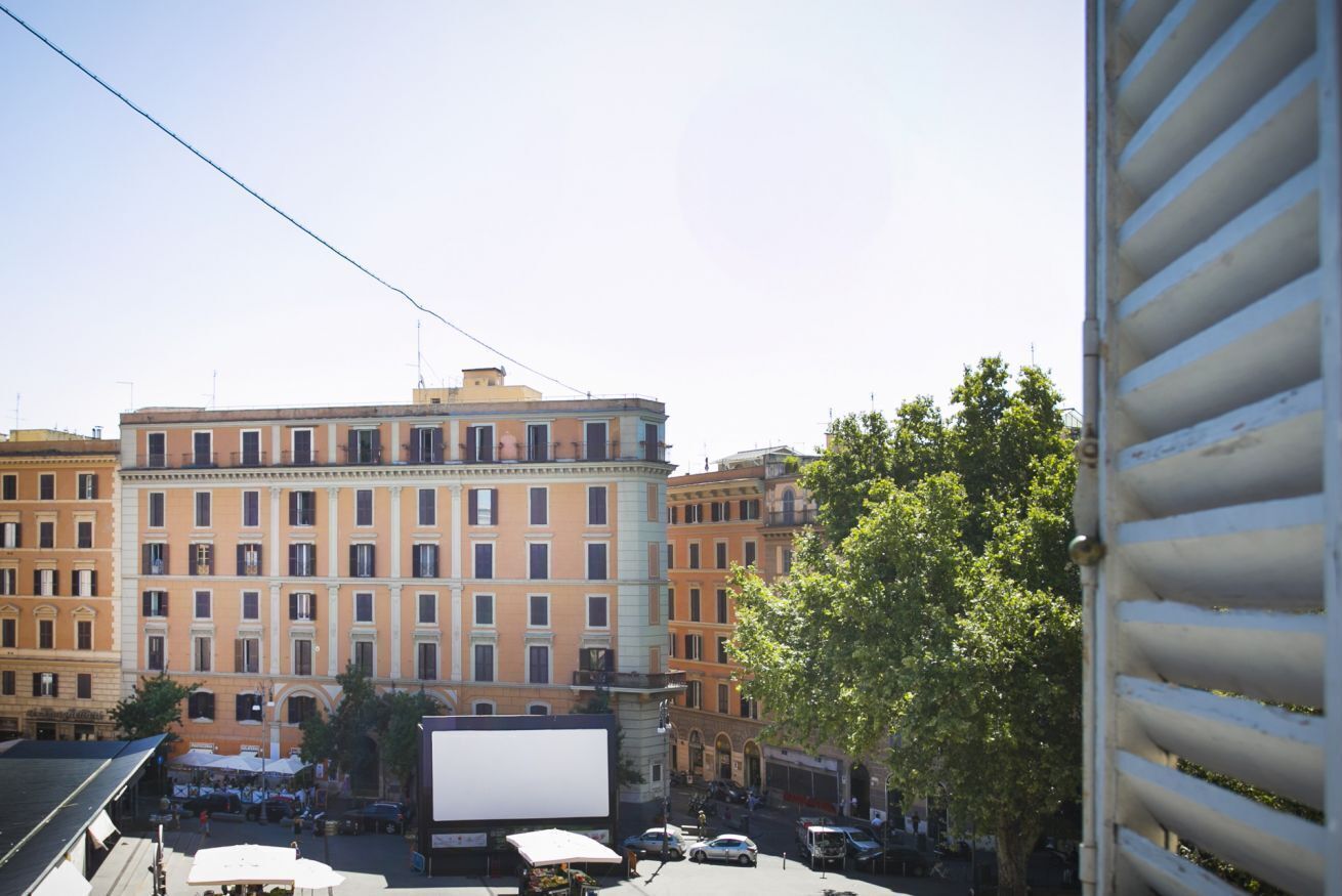 Un edificio a più piani con un cortile centrale, circondato da altri edifici.