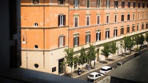 Une rangée d’immeubles à étages multiples, caractérisés par une disposition uniforme des fenêtres, et une rue devant.