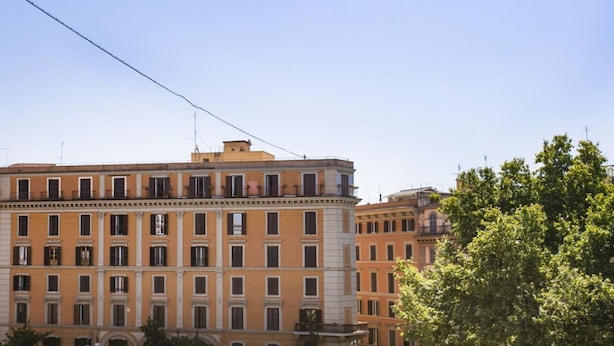Un immeuble à plusieurs étages, de style architectural classique, caractérisé par une façade symétrique avec des fenêtres régulièrement espacées et une entrée centrale.