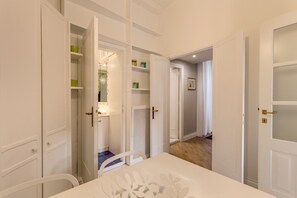 Spacious living area with a central table and chairs, featuring multiple doors leading to separate rooms.