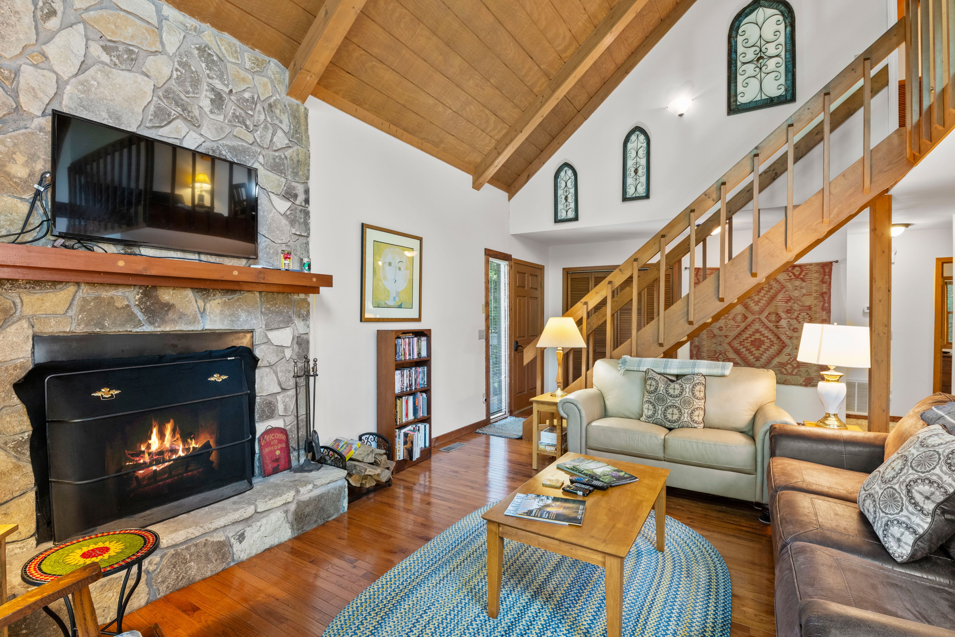 A spacious living room with a fireplace, a staircase, and a cozy seating area.