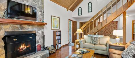 A spacious living room with a fireplace, a staircase, and a cozy seating area.