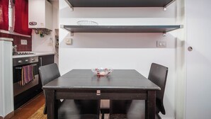 A compact kitchen with a dining table, chairs, and a red lantern. - independent apartment in Trastevere (Roma)