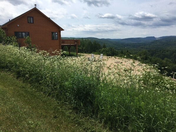 A wooden cabin with a balcony overlooking a valley. - Gorgeous Cottage in the Heart of Nature ! (Saint-Zénon)