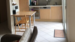 Une cuisine compacte dotée de meubles en bois, d’une hotte en acier inoxydable et d’un lave-vaisselle.