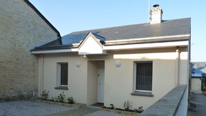 Un petit bâtiment d’un seul étage, doté d’un toit en pente, d’une porte d’entrée et de deux fenêtres.