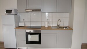 A compact kitchen with a microwave, toaster, sink, and oven. - 3 The Courtyard Award Winning 4 Star Vineyard Gite (Monbadon)