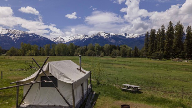 A tent set up in a grassy field with a mountain range in the background. - Glamping Tent at the base of the mountains outside Joseph, Oregon at Evans Farm. (Joseph)