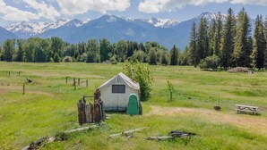 A tent in a grassy field with mountains in the background. - Glamping Tent at the base of the mountains outside Joseph, Oregon at Evans Farm. (Joseph)