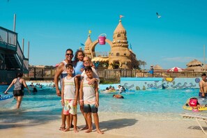 A swimming pool area with a large sandcastle structure in the background.