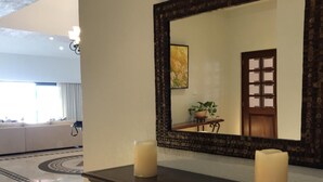 A hotel lobby with a large mirror, a dark wooden console table with two candles, and a patterned floor. - Fabulous Developers Beachfront PENTHOUSE XMAS & NY WKS @ Playa Grande Resort (Cabo San Lucas)