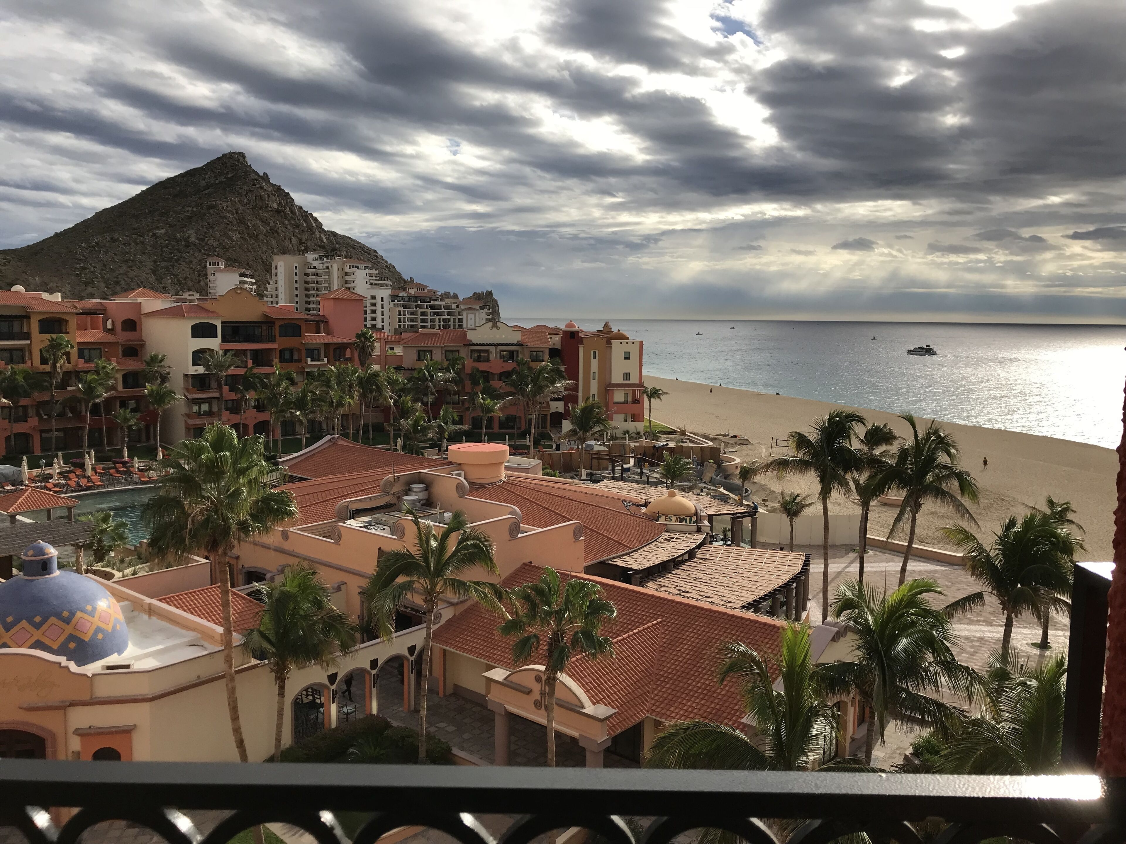 A resort with a beach view, including a pool area and palm trees.