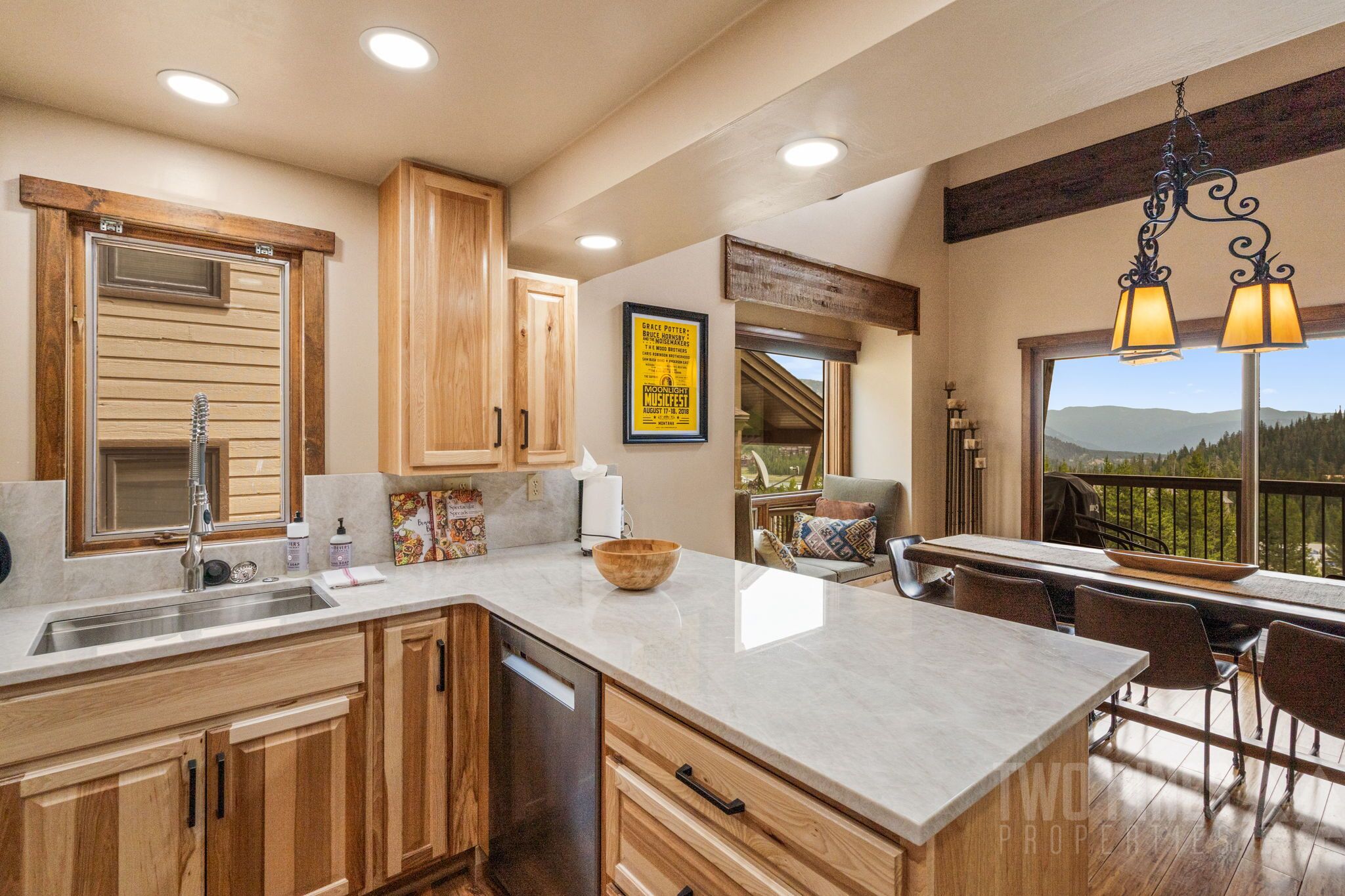 A kitchen with wooden cabinets, a large island with a bowl, and a view of the outdoors.