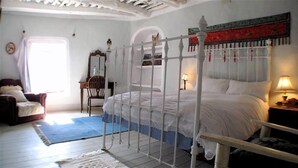 Une chambre à coucher avec un lit à baldaquin, une chaise en bois, un bureau et un miroir.