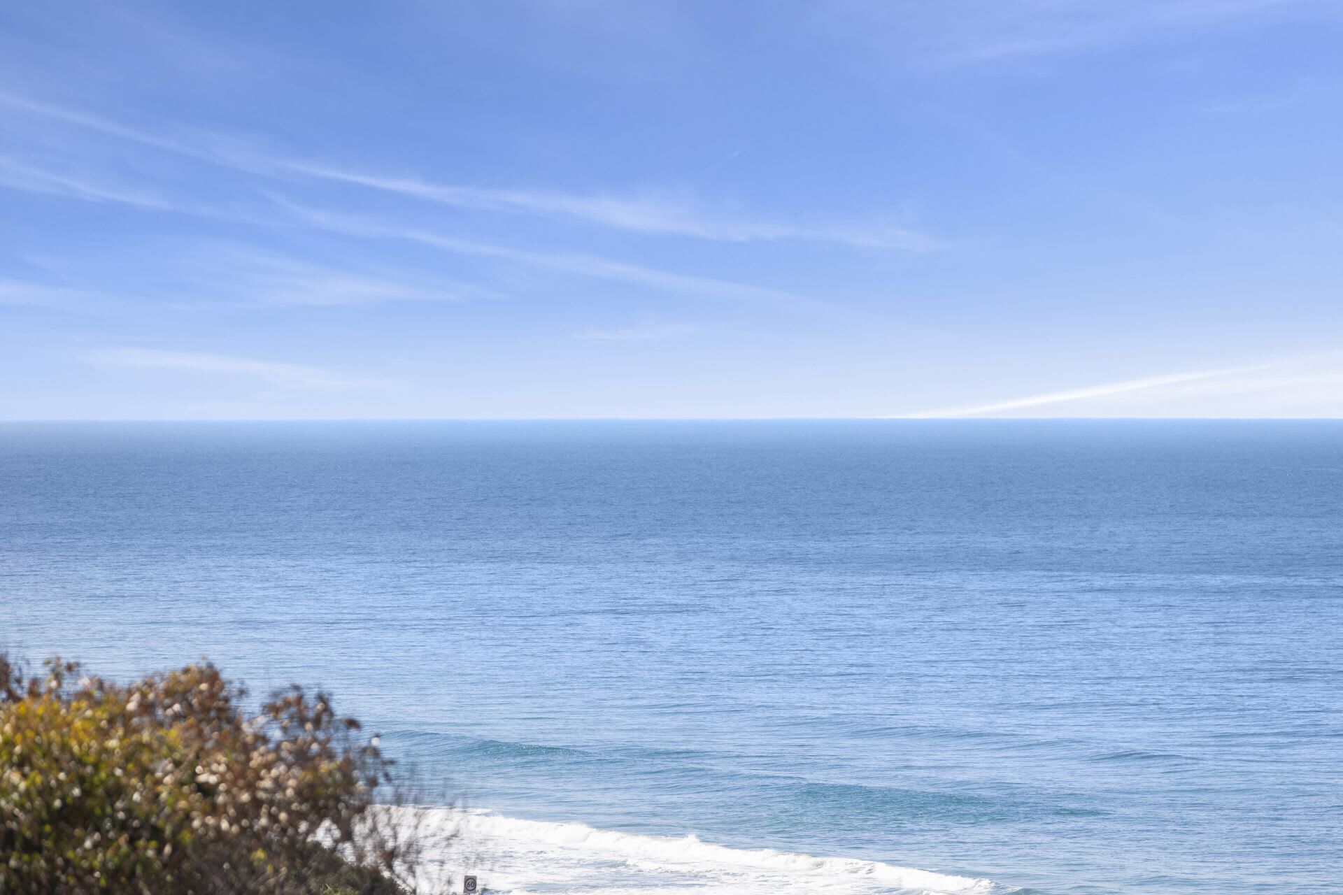 Une vue sur la côte, avec un ciel dégagé et une mer calme.