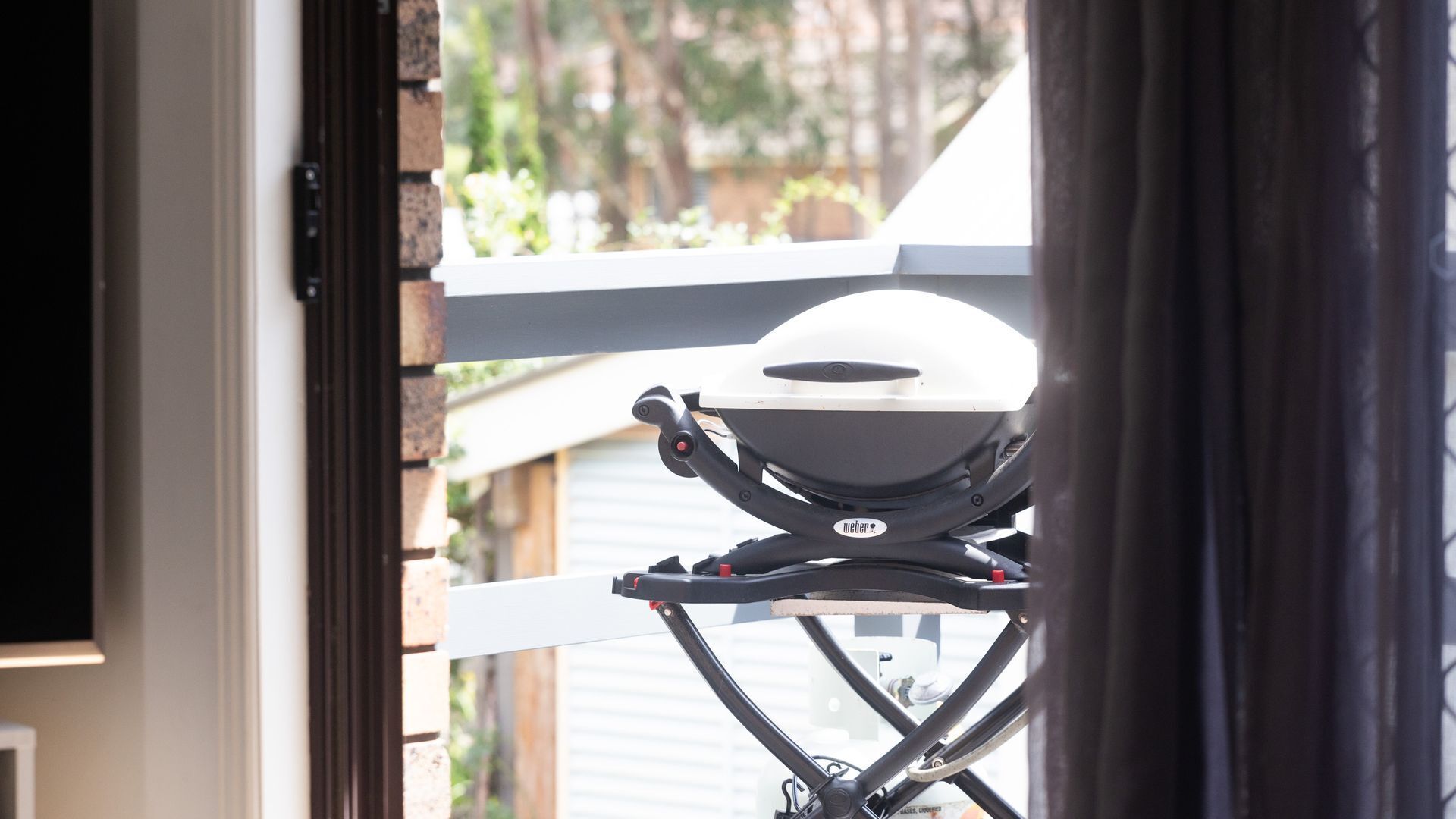 Ein Weber-Grill auf einem Balkon.