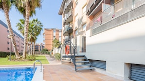 A residential building with a swimming pool, outdoor stairs, and balconies.