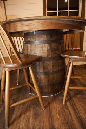 Ein Holztisch mit Fass-Optik und zwei Holzstühlen.