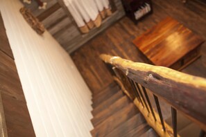 Eine Holztreppe mit einem Metallgeländer, einem Holzboden und einer weißen Wand.