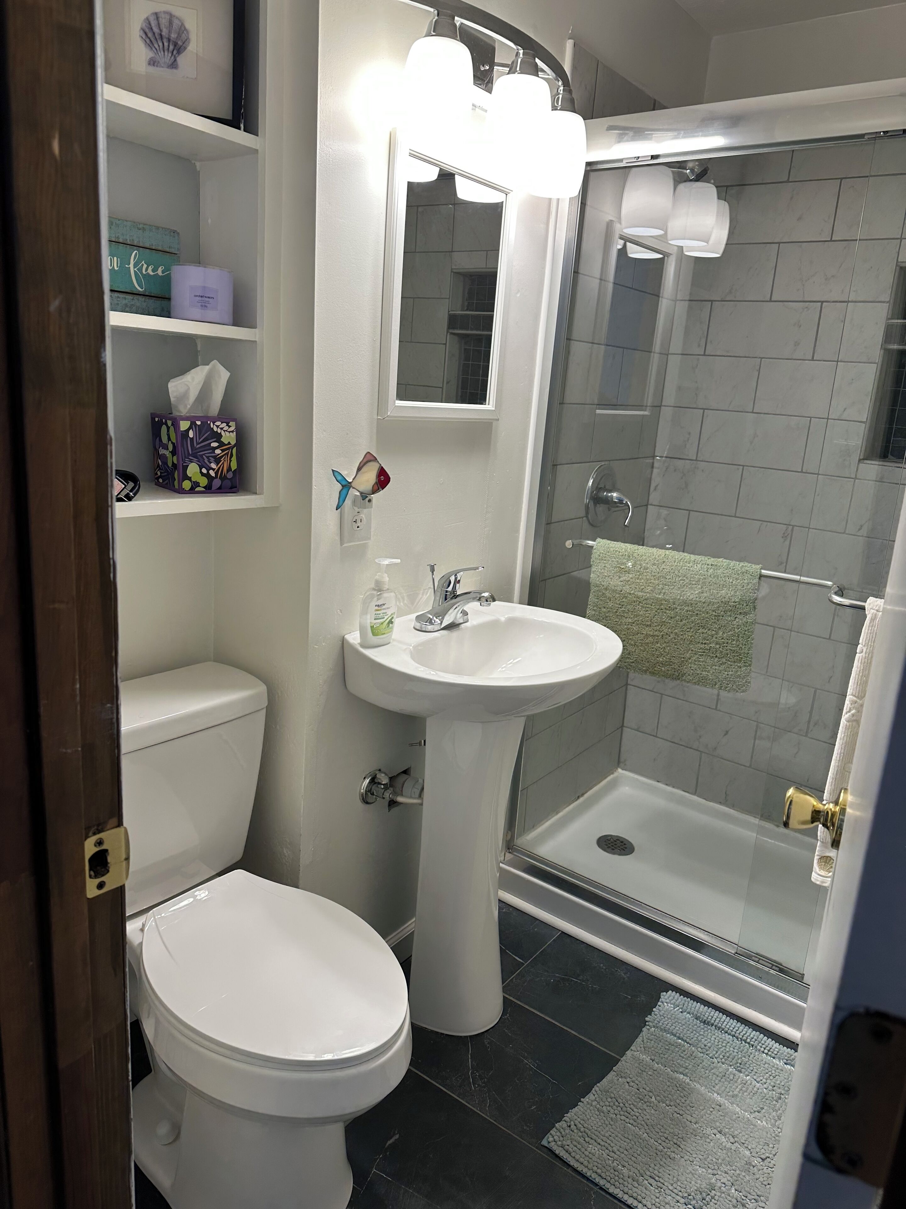 Een badkamer met toilet, wastafel en douchecabine.