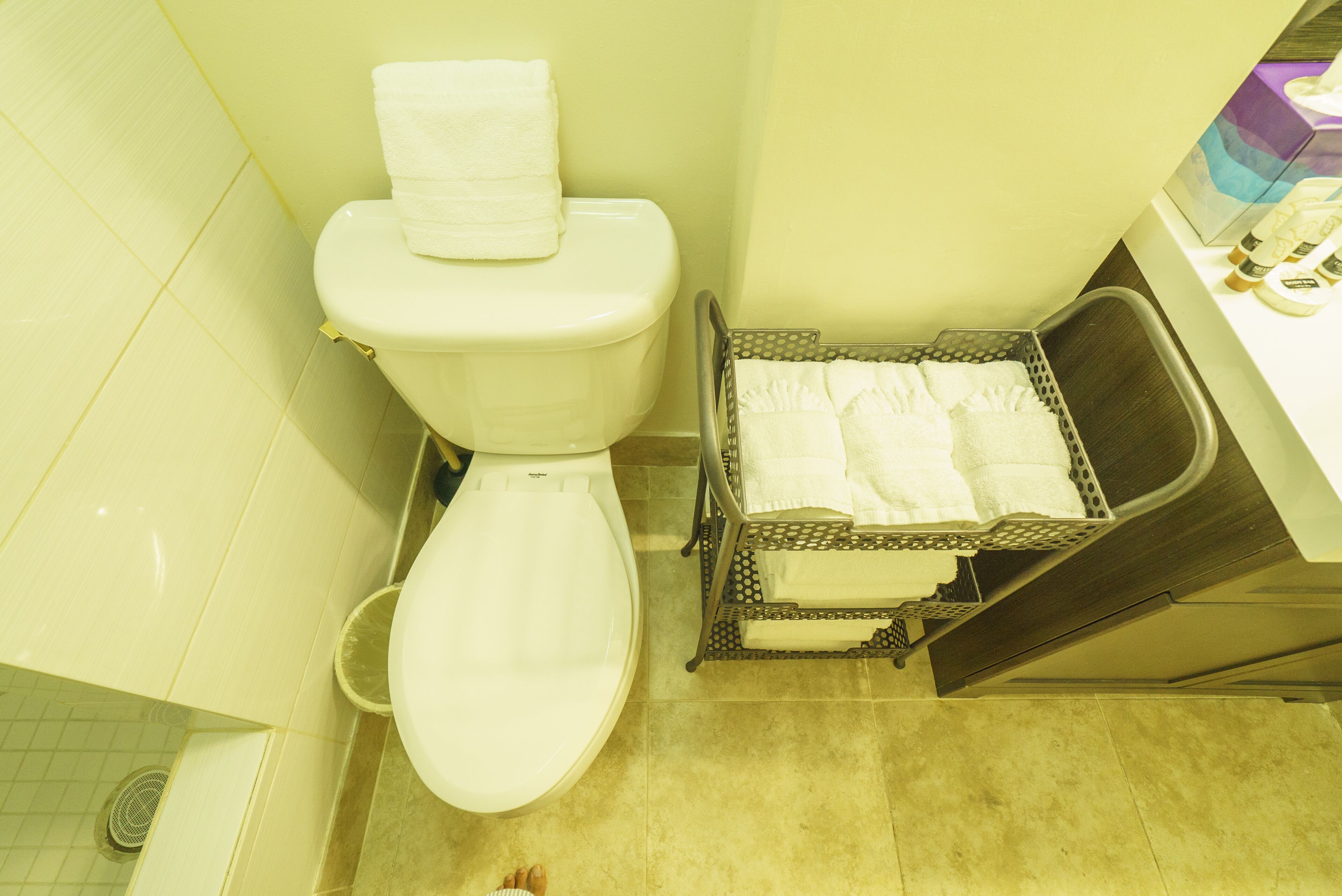 Un baño con inodoro, bidé y toallero con toallas dobladas.