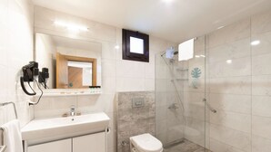Une salle de bain moderne avec un lavabo, des toilettes et une douche à parois de verre.