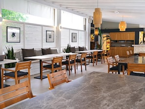 A modern dining area with wooden furniture and a large marble table. - Dorman Suites Hotel (Bodrum)