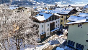 Un quartier résidentiel enneigé, avec des bâtiments modernes, une église bien visible et une rivière en arrière-plan.