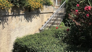 A building with a beige facade, a wooden door, and a balcony with a metal railing. - Stunning views, Space, Charm, Great Pool, Ideal Amalfi Coast location! (Furore)