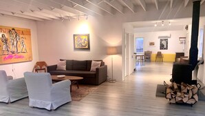 Ein Wohnzimmer mit einer Couch, Sesseln, einem Couchtisch, einem Kamin und einem Gemälde an der Wand.