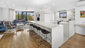 Un appartement moderne comprenant un espace de vie, une cuisine et un coin repas.