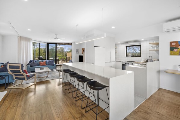 A modern apartment with a living area, kitchen, and dining space.