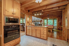 A spacious kitchen with wooden cabinets, a built-in microwave, and a central island with a sink.